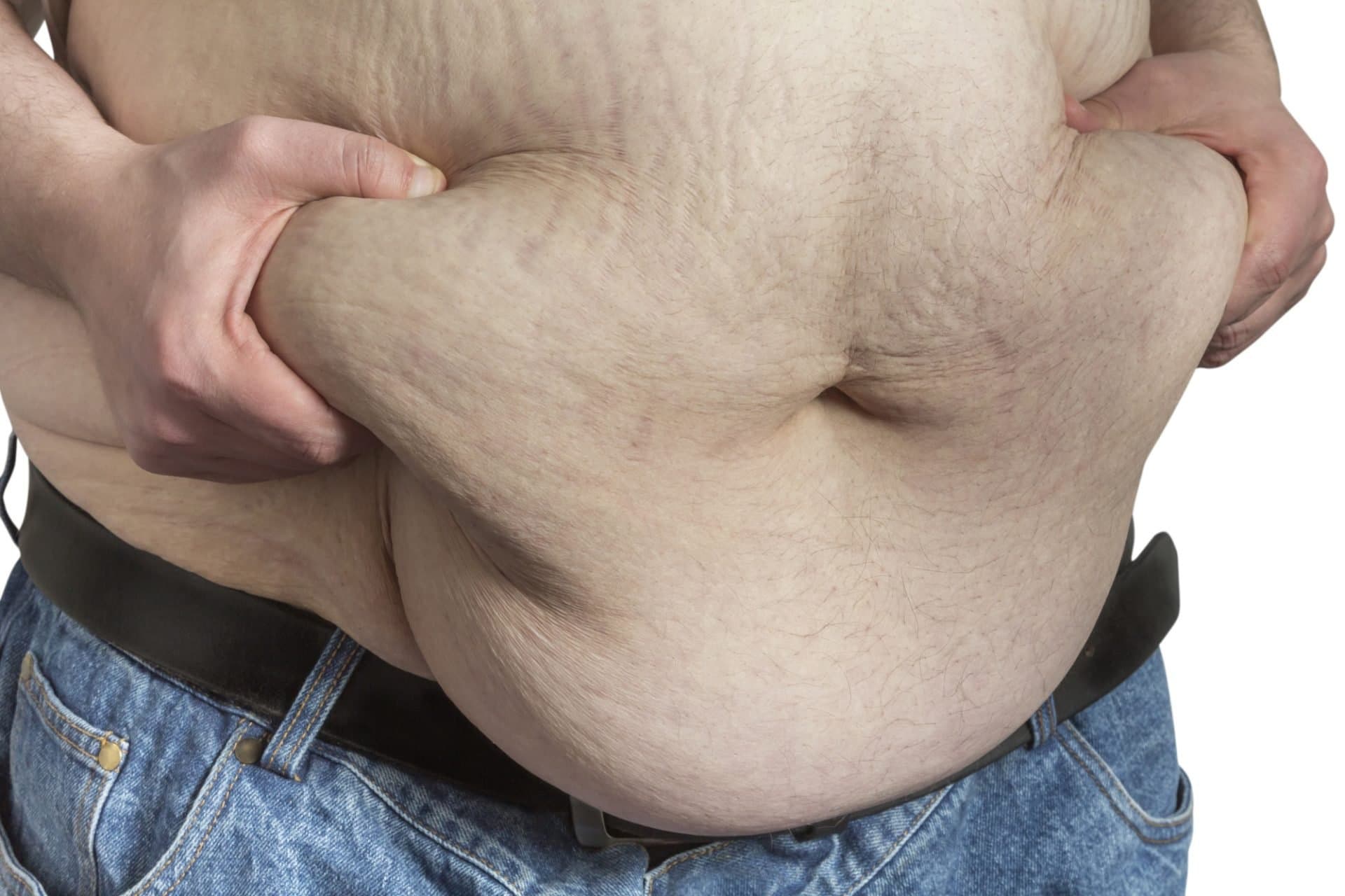 A man pinching the extra fat around his midsection.