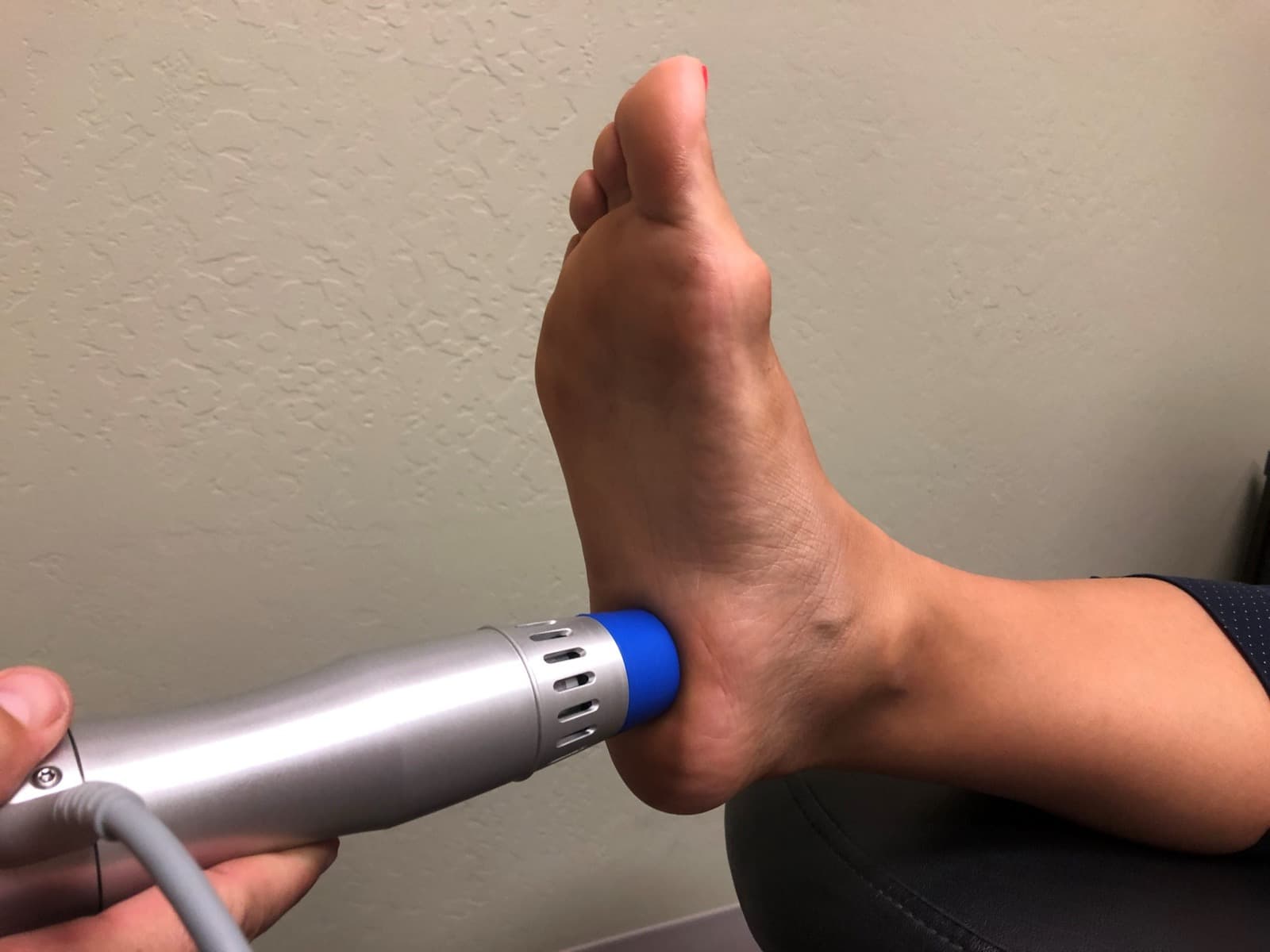 A shockwave therapy applicator held against the heel of a patient's foot at LifeCare Chiropractic.
